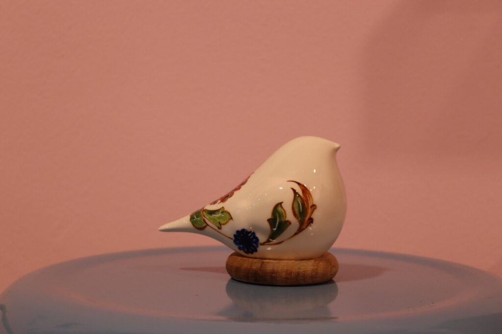 مجسمه سرامیکی دست‌ساز طرح مرغ امین با نقاشی گل و پایه چوبی