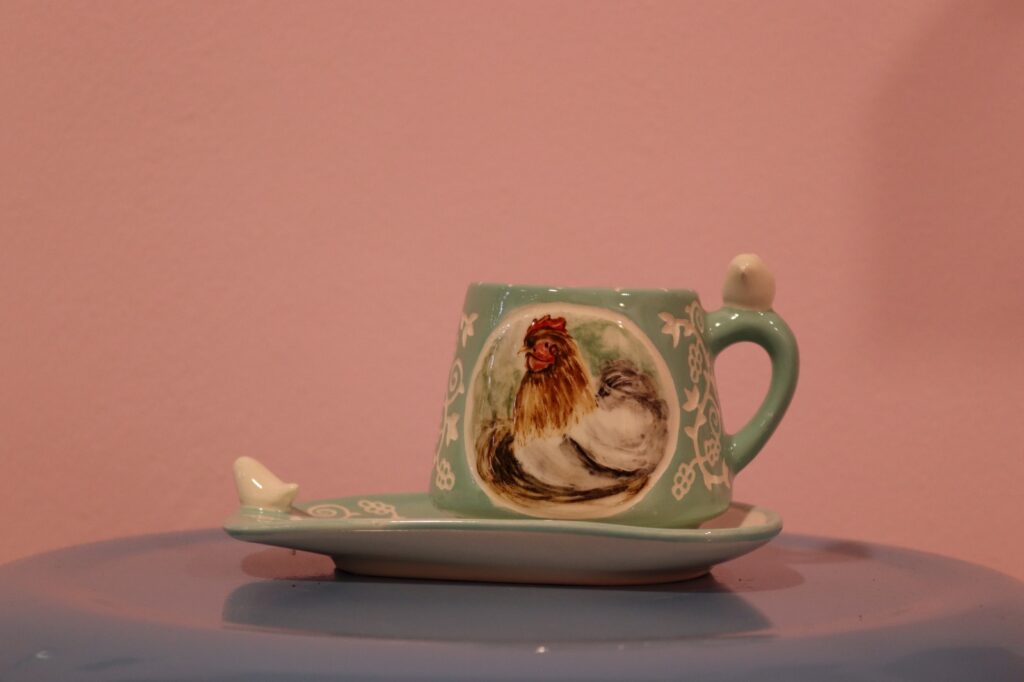 فنجان و زیر فنجانی سرامیکی دست‌ساز با طرح مرغ و رنگ سبز ملایم و تزئینات دستی